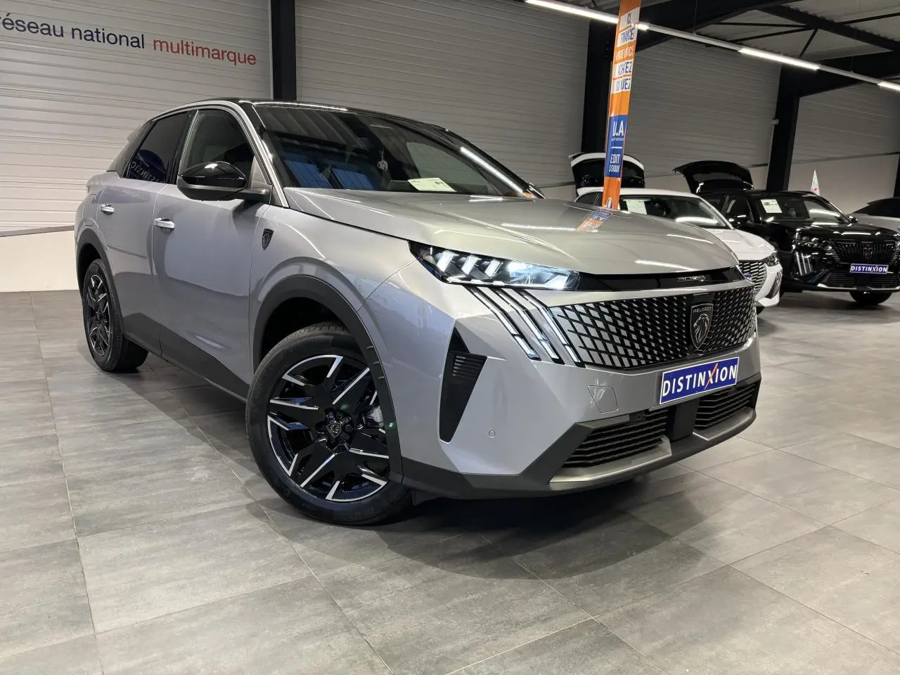 Peugeot 3008 gris Artense en 3/4 avant droit, avec calandre noire à motif géométrique et jantes alliage noires.