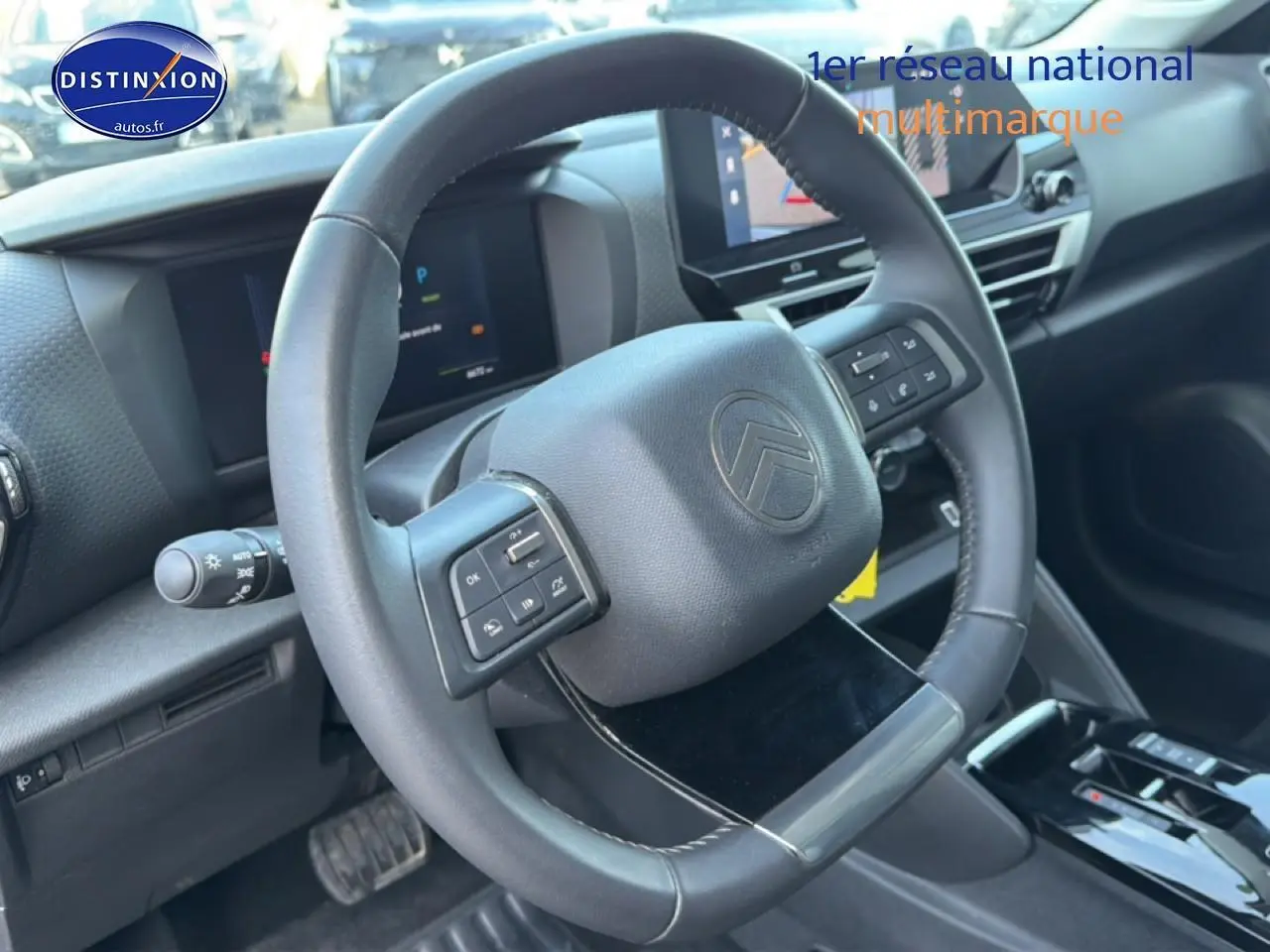 Vue intérieure centrée sur le volant multifonctions de la Citroën C4 électrique 2025, avec tableau de bord numérique.