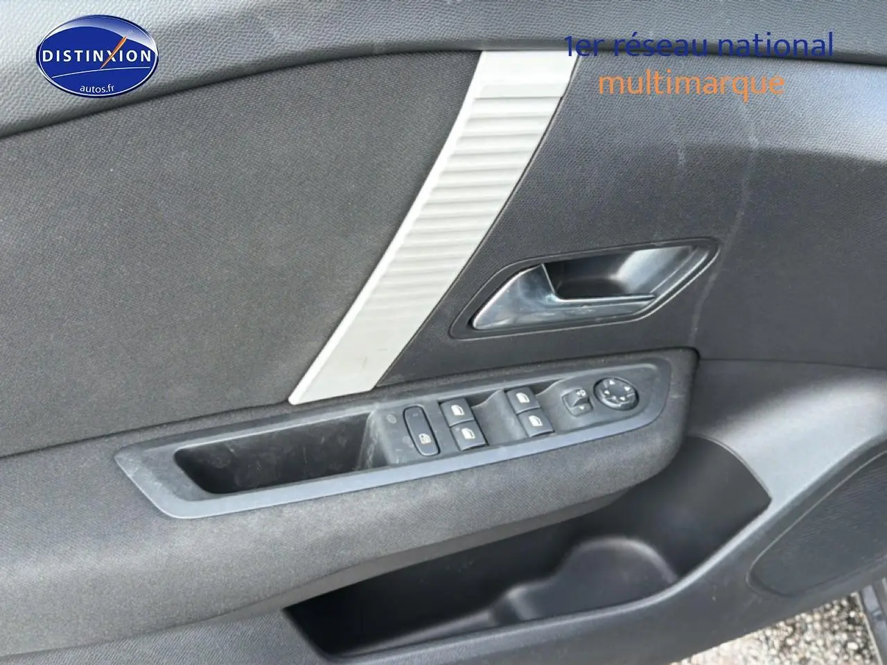 Intérieur côté gauche de la porte avant d'une Citroën C4 électrique 2025, avec commandes de vitres et poignée gris foncé.