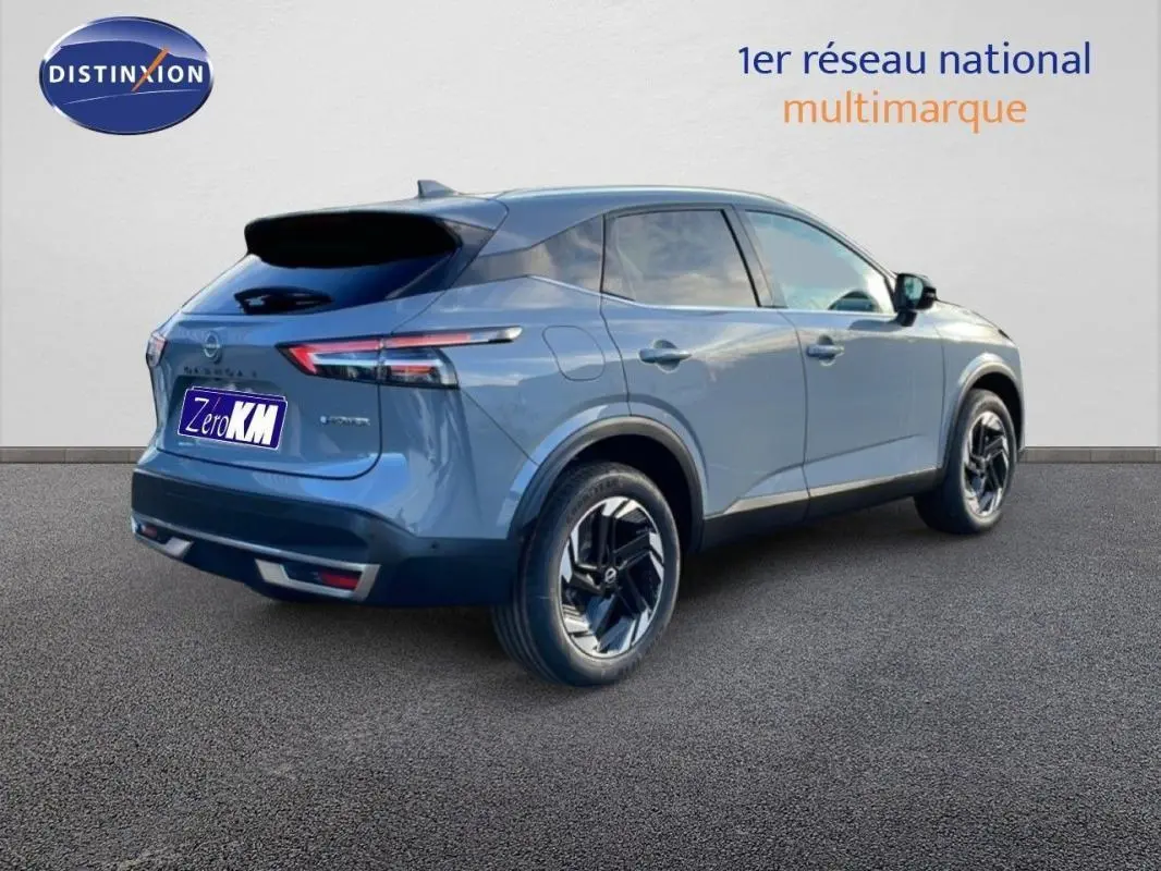 Nissan Qashqai 1.5 E-POWER gris vu en 3/4 arrière droit avec jantes aluminium et barres de toit visibles.