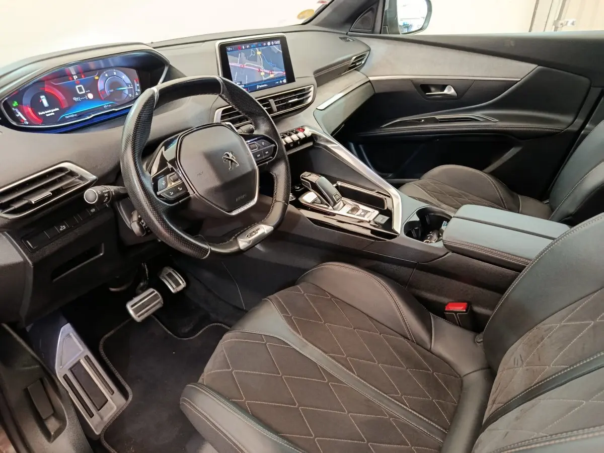 Intérieur du Peugeot 5008 gris clair, vue côté conducteur, avec tableau de bord numérique et écran tactile central.