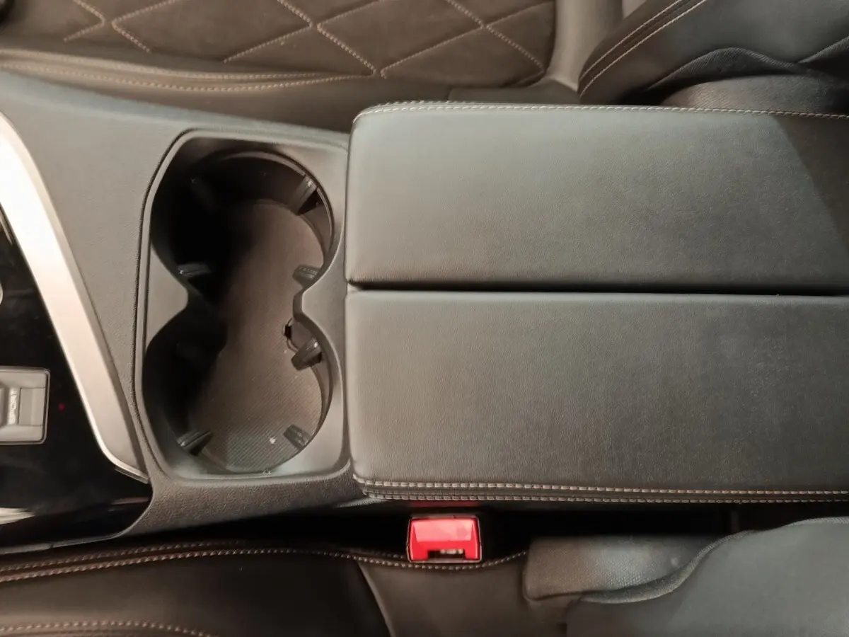 Gros plan sur la console centrale noire avec porte-gobelets et accoudoir en cuir du Peugeot 5008 gris clair 2019.