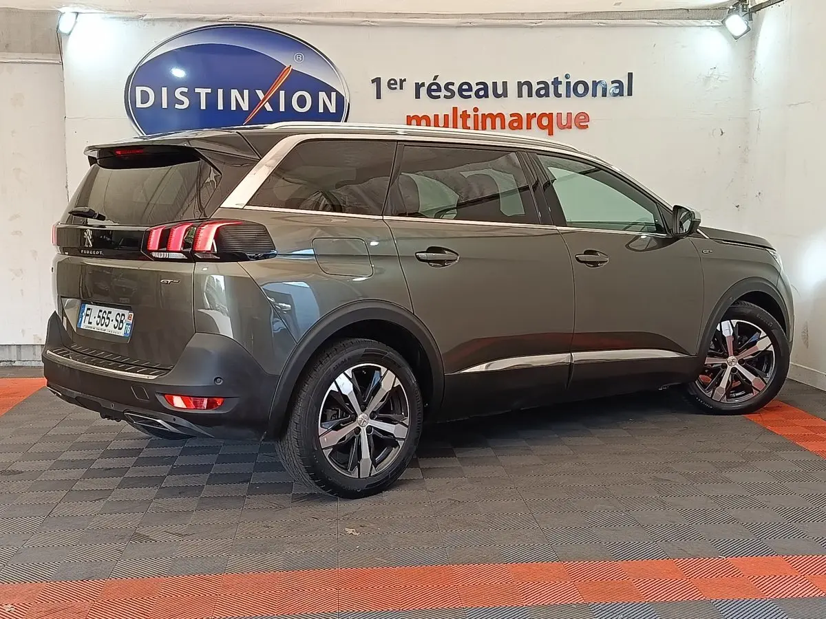 Peugeot 5008 BlueHDi 180 gris clair, vue 3/4 arrière droit, feux LED et jantes alliage distinctives.
