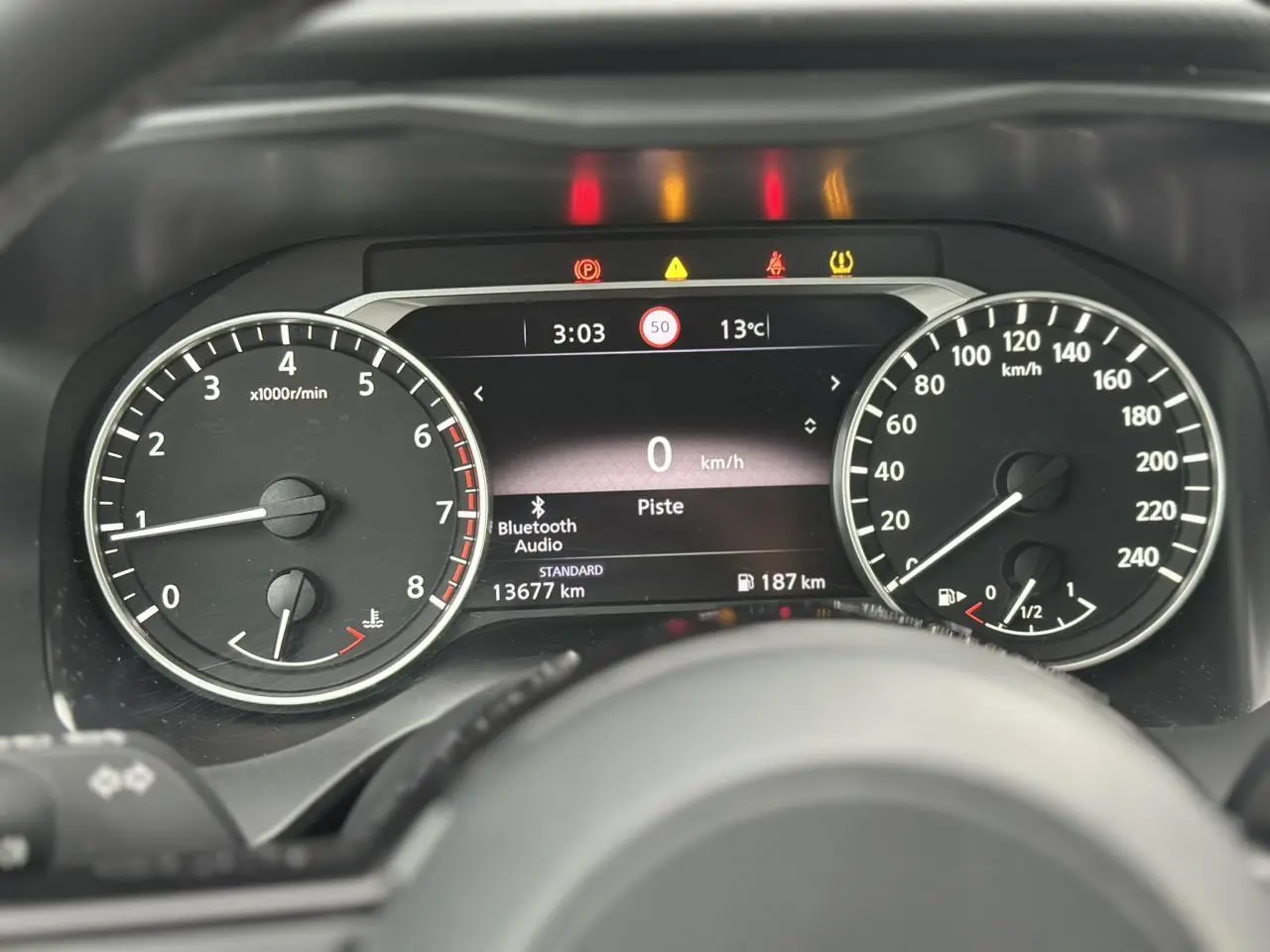 Vue rapprochée du tableau de bord du Nissan Qashqai 2025, affichage numérique avec compte-tours et vitesse.