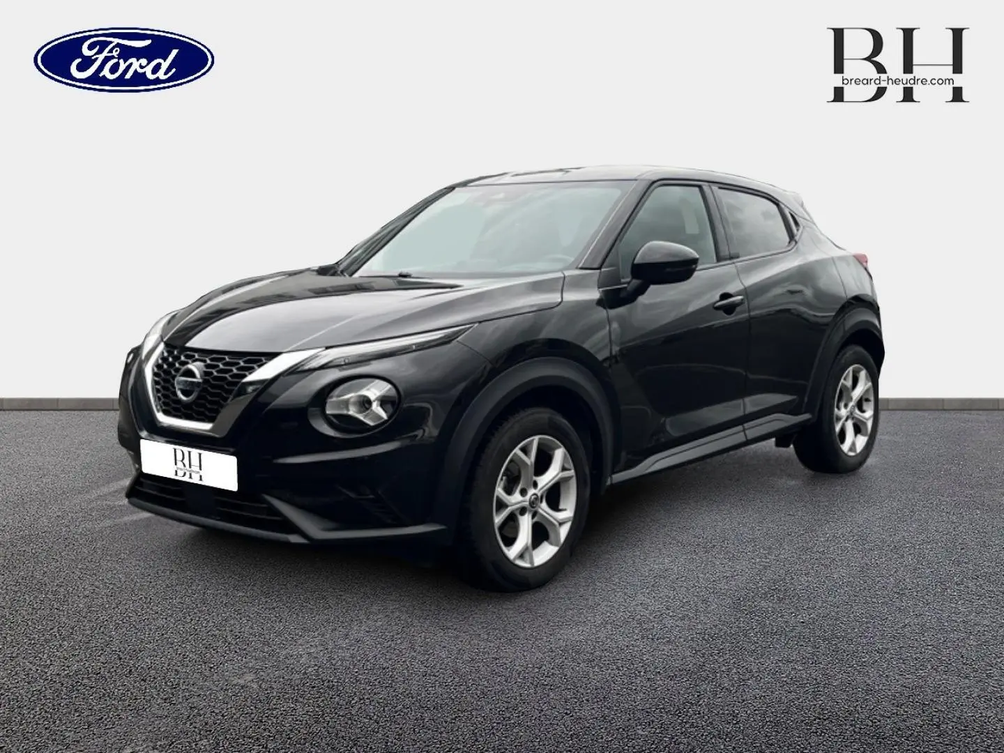 Nissan Juke noir métallisé en 3/4 avant droit, avec jantes alu et calandre distinctive V-Motion.