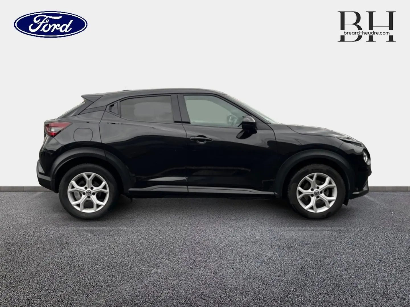 Profil droit d'un Nissan Juke noir métallisé 2020 avec jantes alliage et lignes compactes distinctives.