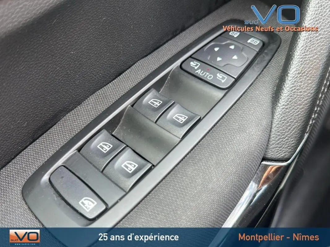 Gros plan sur les commandes électriques des vitres côté conducteur du Renault Kadjar bleu foncé 2021.