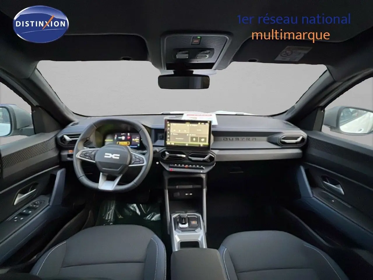 Vue intérieure avant du Dacia Duster 2025, tableau de bord noir avec écran tactile central et volant multifonction.