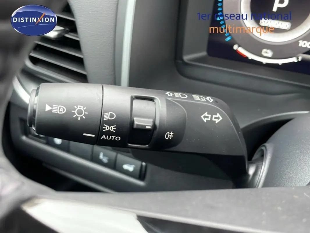 Gros plan sur la commande des feux et clignotants à gauche du volant du Nissan Qashqai blanc 2025.