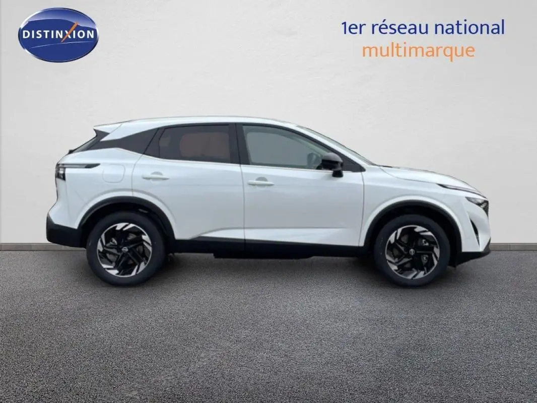 Vue latérale droite du Nissan Qashqai blanc 2025 avec jantes aluminium et toit noir contrasté.