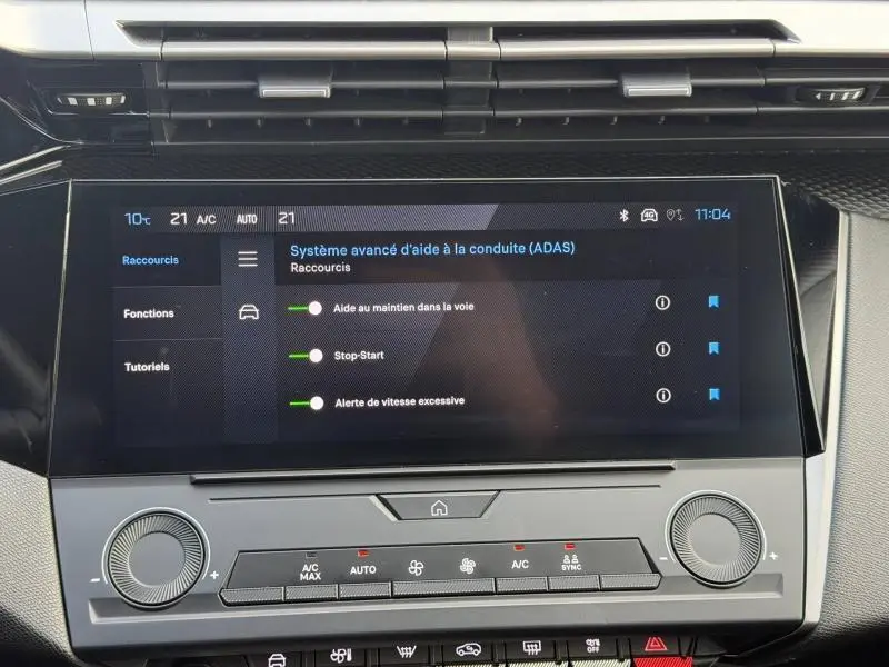 Vue rapprochée de l’écran tactile central affichant les aides à la conduite du Peugeot 308 blanc Okénite 2024.