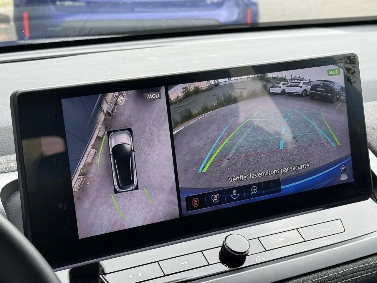Écran tactile intérieur montrant la caméra 360° du Nissan Qashqai Bleu Magnétique en vue arrière et vue du dessus.