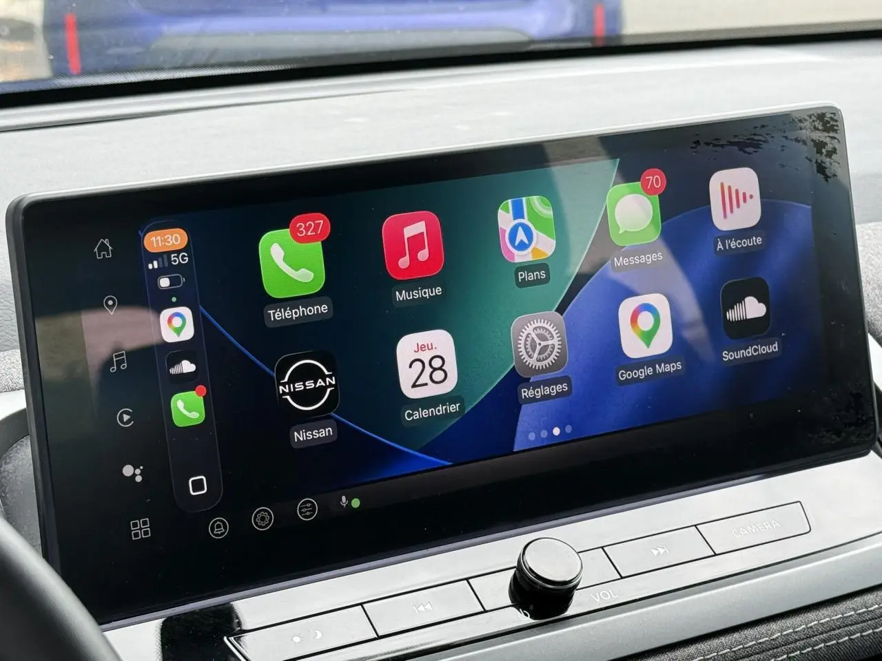 Écran tactile central du Nissan Qashqai 2025 affichant Apple CarPlay avec icônes colorées, vue intérieure rapprochée.