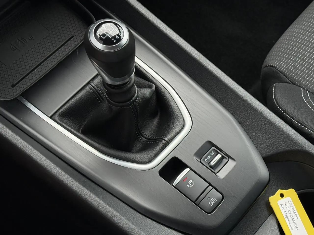 Gros plan sur la console centrale du Nissan Qashqai 2025, mettant en valeur le levier de vitesse manuel et les commandes de frein électrique.