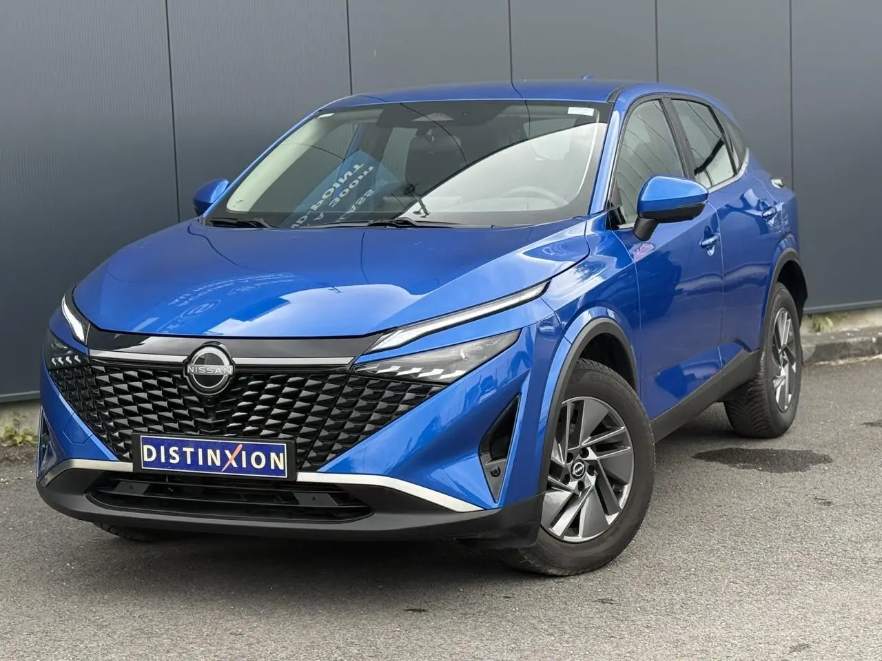 Nissan Qashqai bleu magnétique en 3/4 avant droit, avec calandre noire texturée et jantes alliage 17 pouces.
