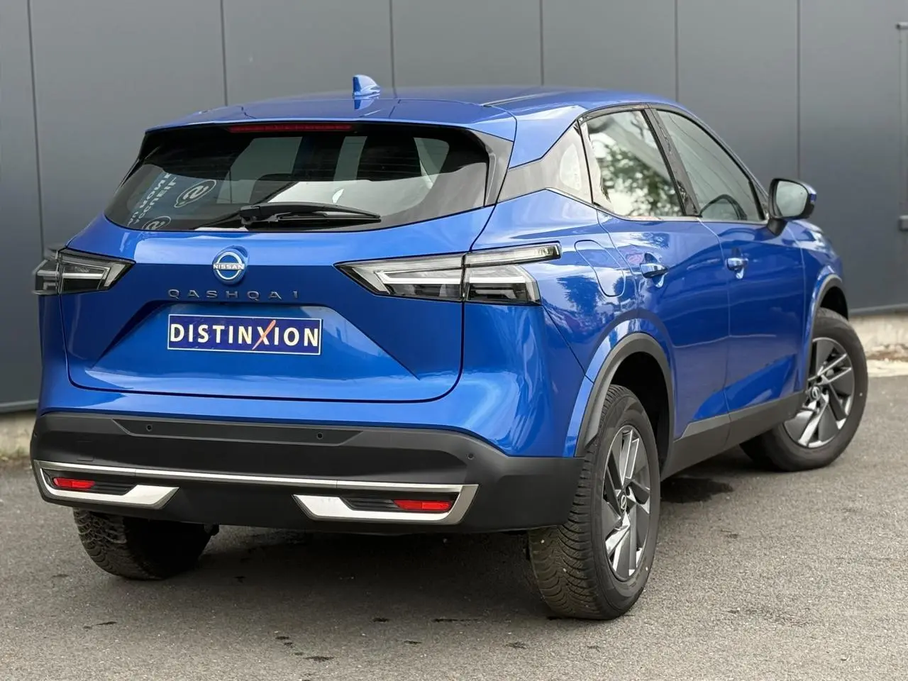 Vue 3/4 arrière droit du Nissan Qashqai bleu magnétique 2025 avec feux LED et jantes alliage 17 pouces.