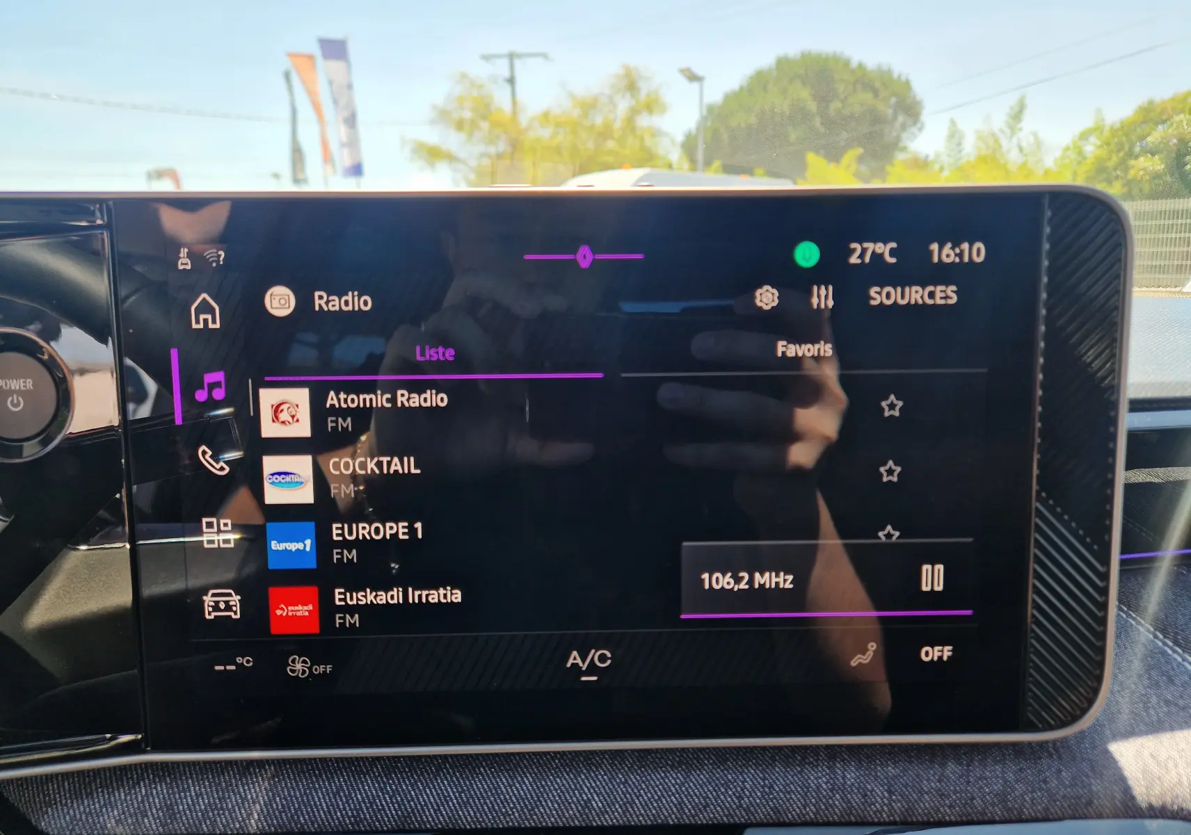 Écran tactile central du Renault R5 E-TECH blanc nacré, affichant la liste des radios FM en intérieur lumineux.