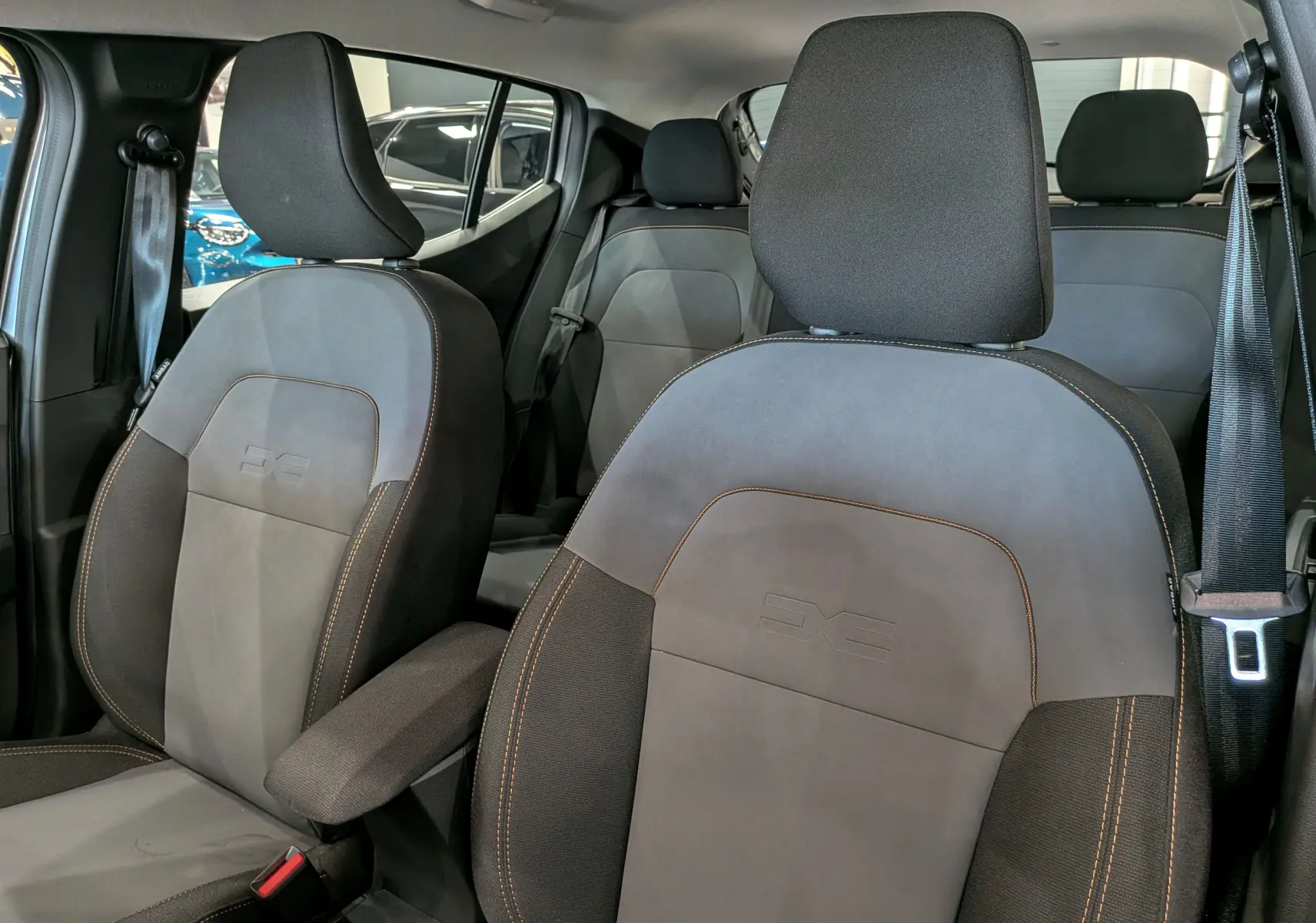 Vue intérieure rapprochée des sièges avant en tissu gris et noir de la Dacia Sandero Stepway TCe 110 CH Extreme 2025.