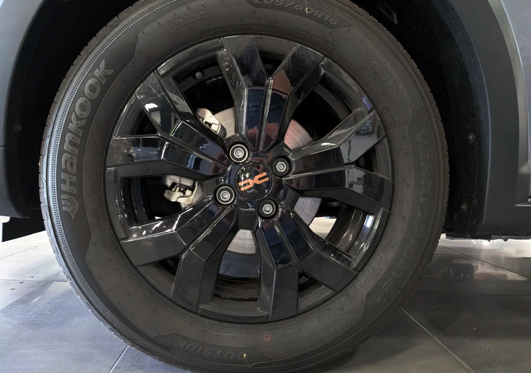 Gros plan sur la roue avant gauche avec jante noire brillante du Dacia Sandero Stepway TCe 110 Gris Schiste 2025.