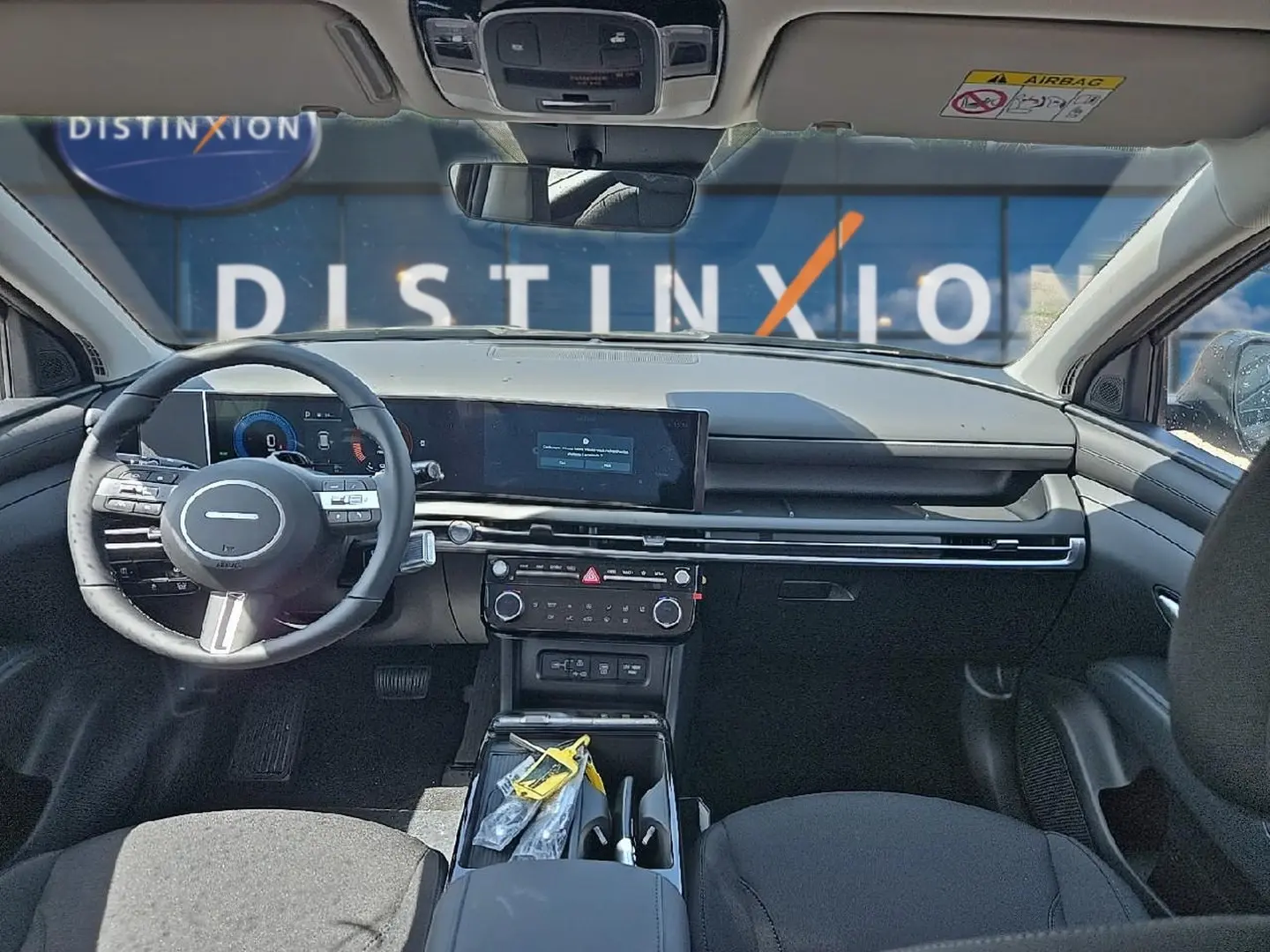 Vue intérieure avant du Hyundai Tucson 2026 noir, avec tableau de bord numérique et volant multifonction cuir.