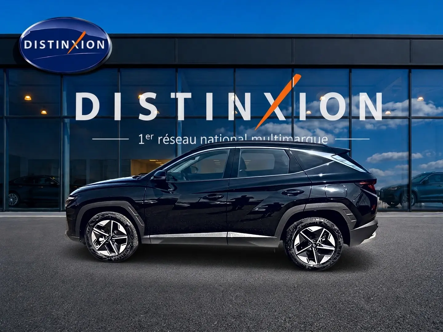 Vue de profil côté gauche d'un Hyundai Tucson noir 2026 hybride garé devant une vitrine avec logo Distinxion.