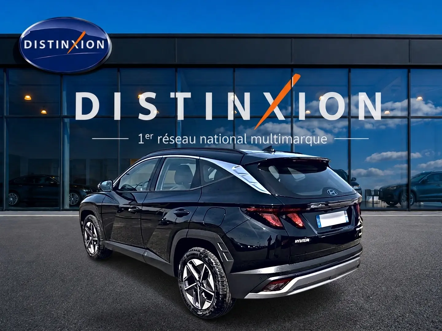 Vue 3/4 arrière droite d'un Hyundai Tucson noir 2026 hybride, avec jantes alu et feux LED distinctifs.