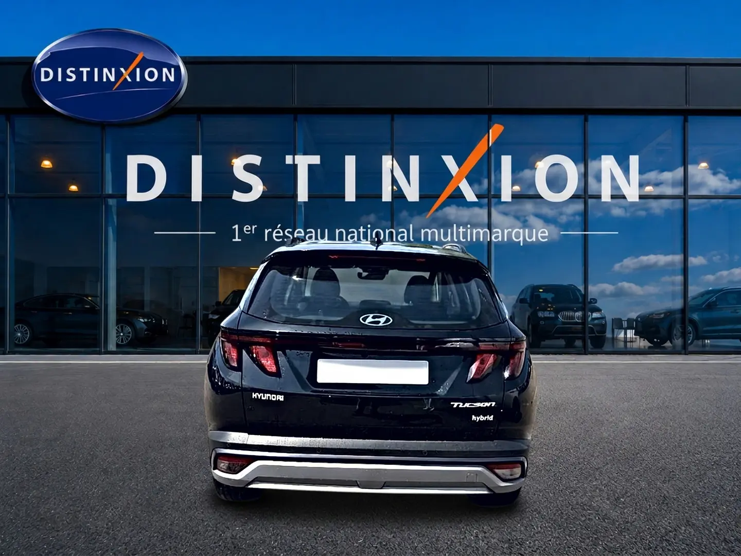 Vue arrière d'un Hyundai Tucson noir hybride 2026, avec logo et feux LED distinctifs, devant une vitrine Distinxion.