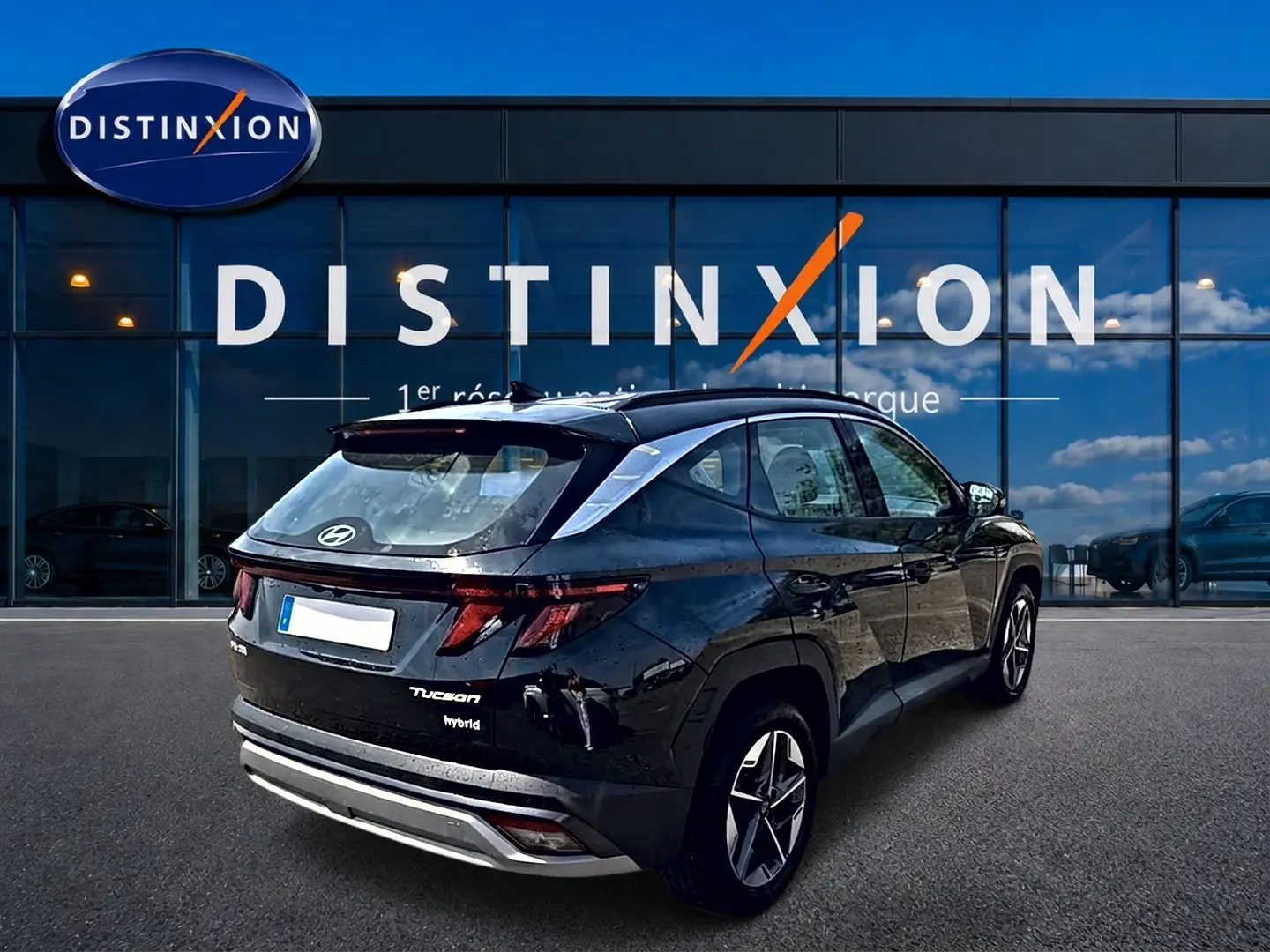 Vue 3/4 arrière droite d'un Hyundai Tucson noir hybride 2026 avec jantes alu et feux LED distinctifs.