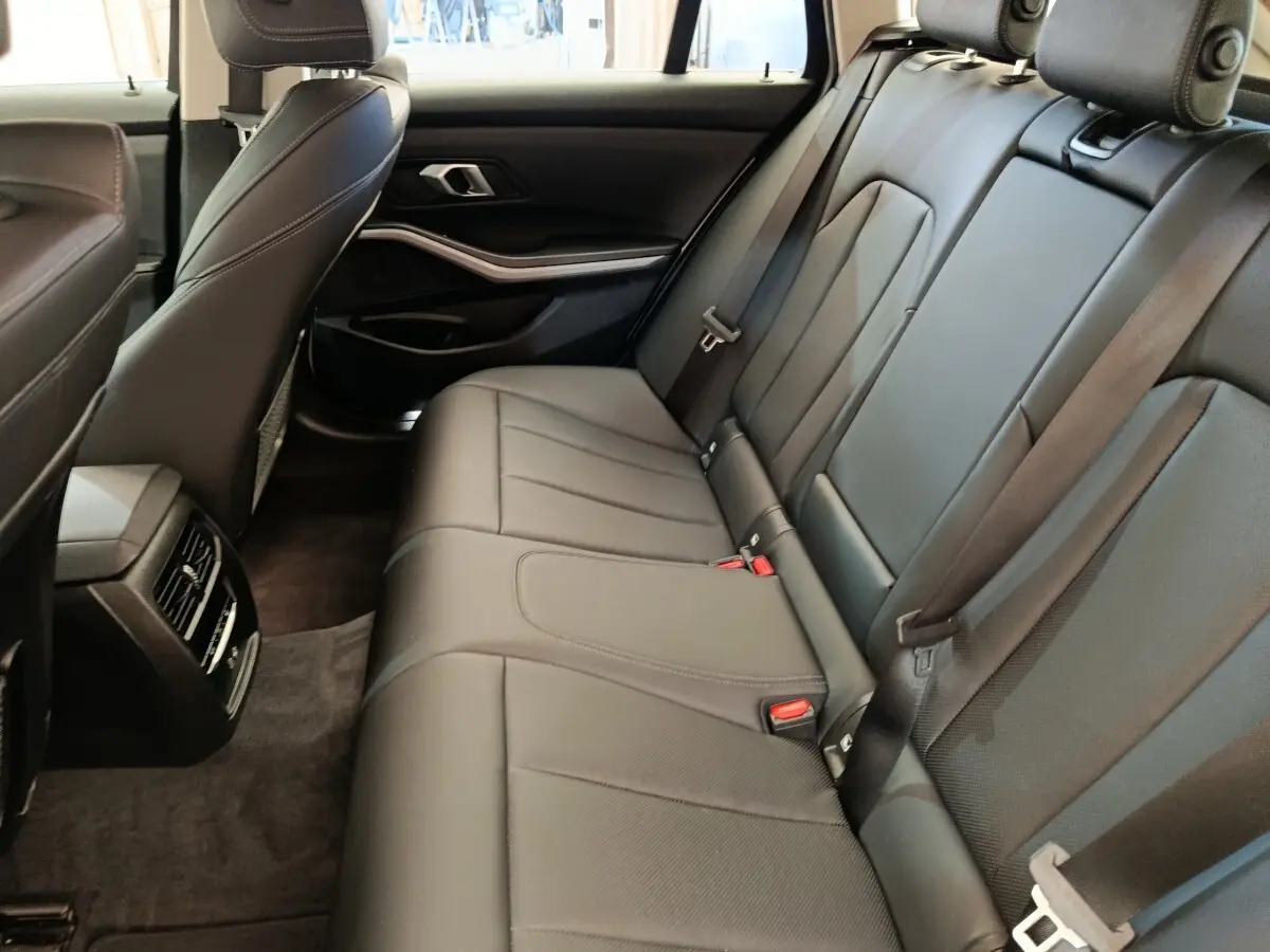 Vue intérieure côté droit des sièges arrière en cuir noir de la BMW Série 3 320e hybride rechargeable.