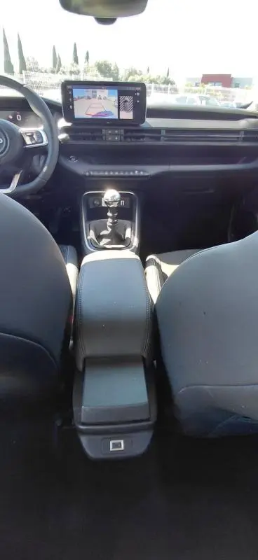Vue intérieure avant du Jeep Avenger blanc 2025 montrant la console centrale avec boîte manuelle et écran tactile.