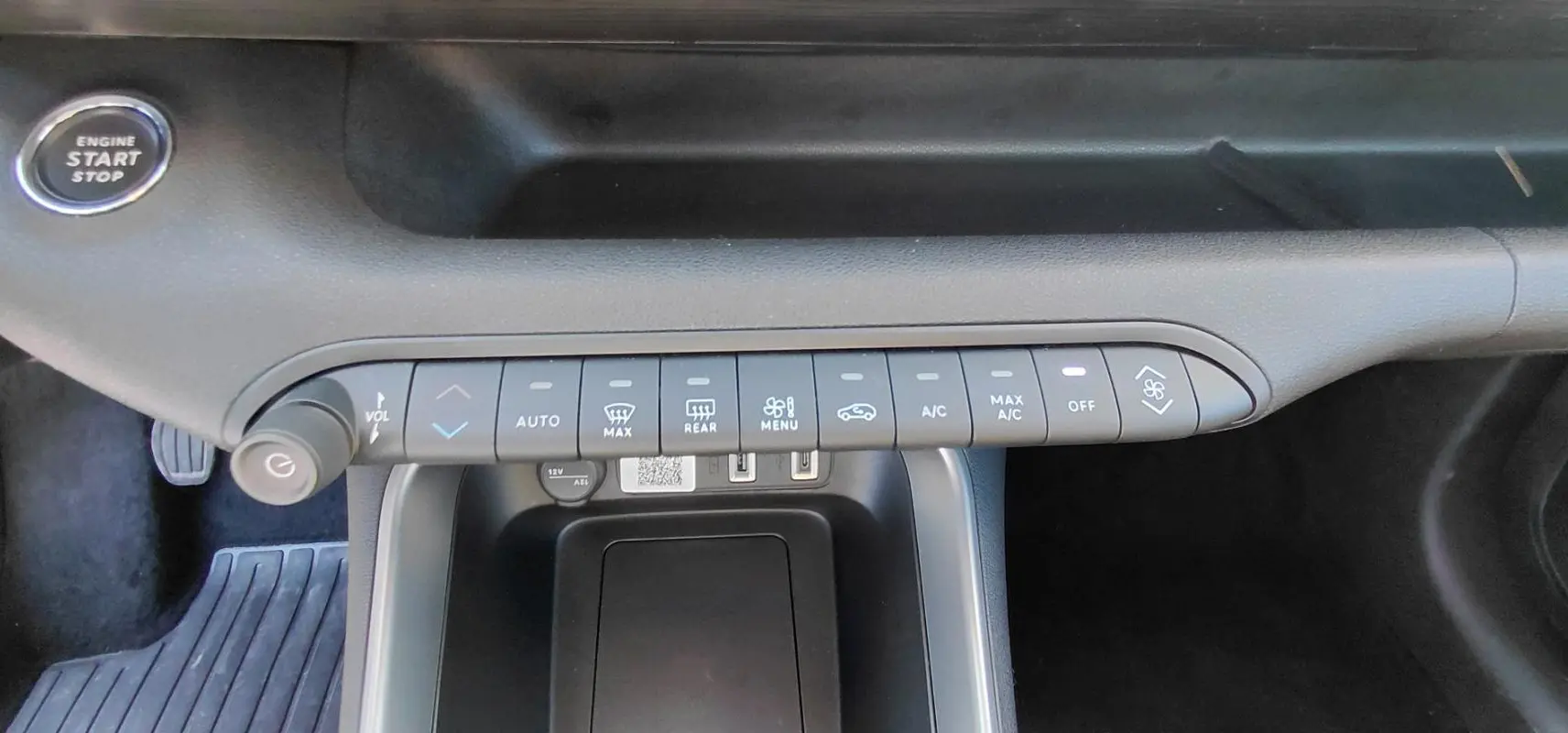 Vue rapprochée de la console centrale noire du Jeep Avenger 2025 montrant les commandes de climatisation et le bouton start/stop.