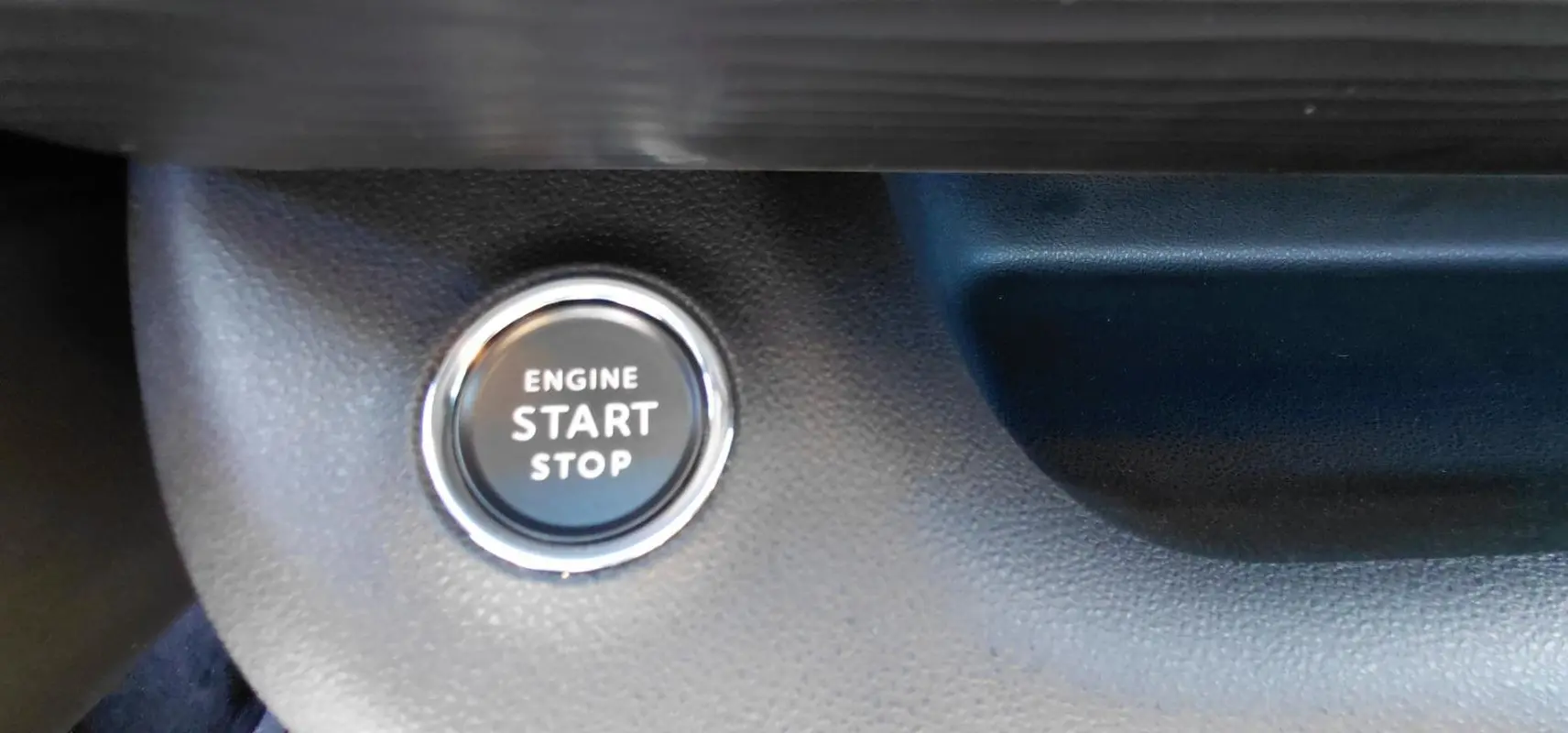 Bouton start/stop moteur en gros plan sur le tableau de bord du Jeep Avenger blanc 2025, version Altitude.