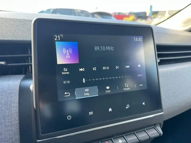 Écran tactile central de la Renault Clio 2025 affichant la radio FM, vu de près côté conducteur.