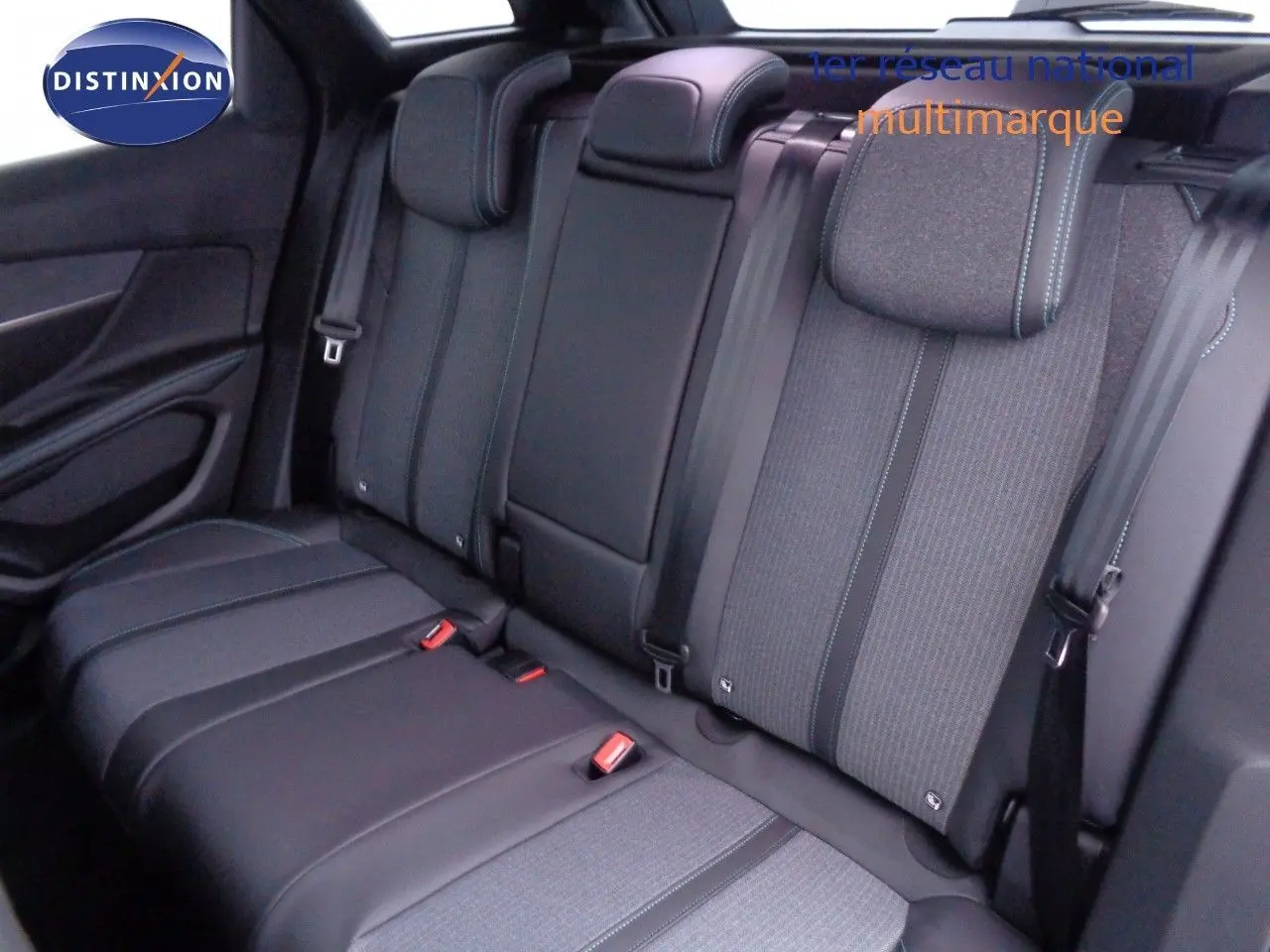 Vue intérieure sur la banquette arrière du Peugeot 3008 2023, avec sièges tissu et cuir noir à surpiqûres bleues.
