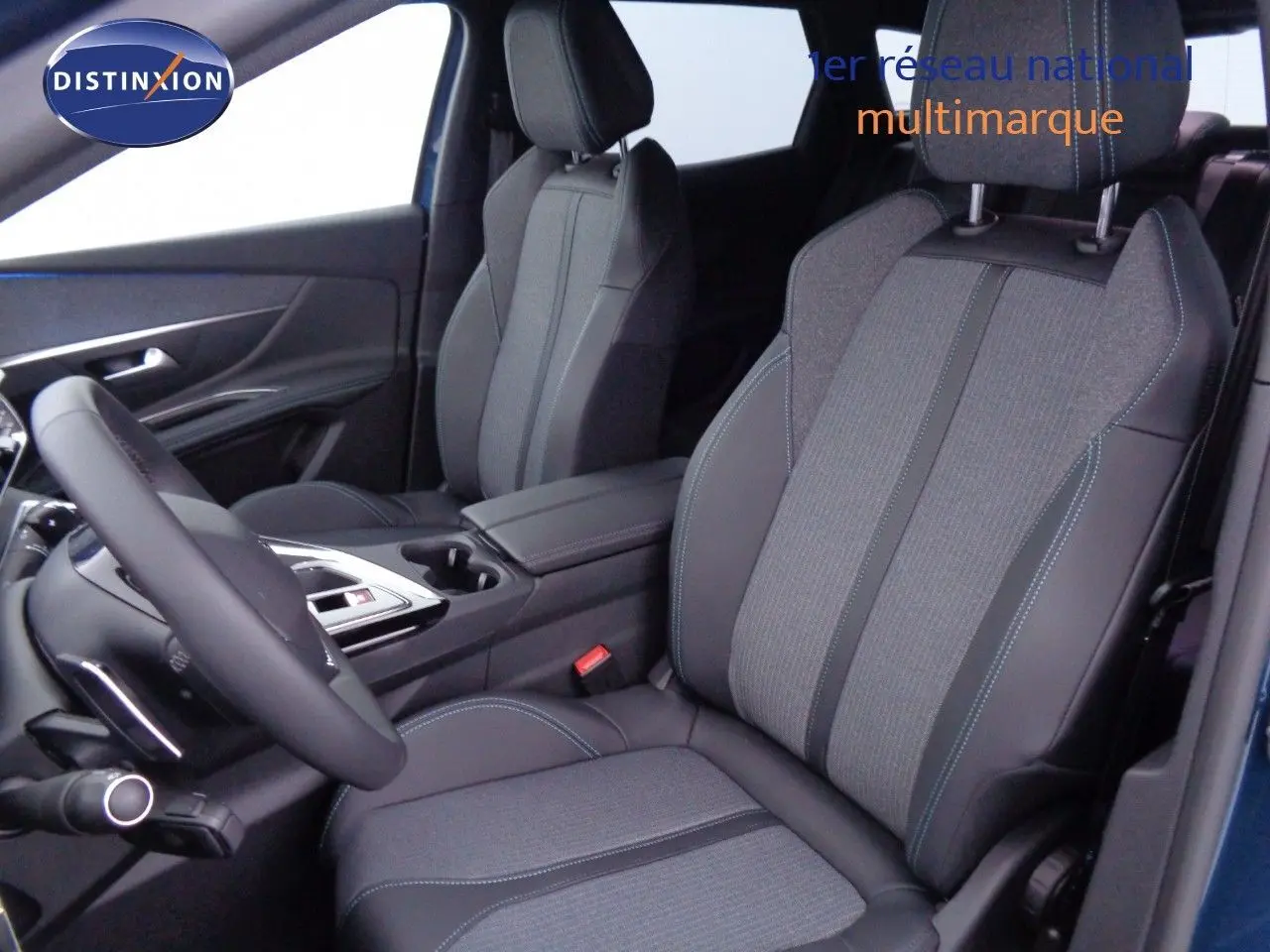 Vue intérieure côté conducteur du Peugeot 3008 2023 bleu Célèbes Métal, sièges tissu et cuir noir avec surpiqûres bleues.