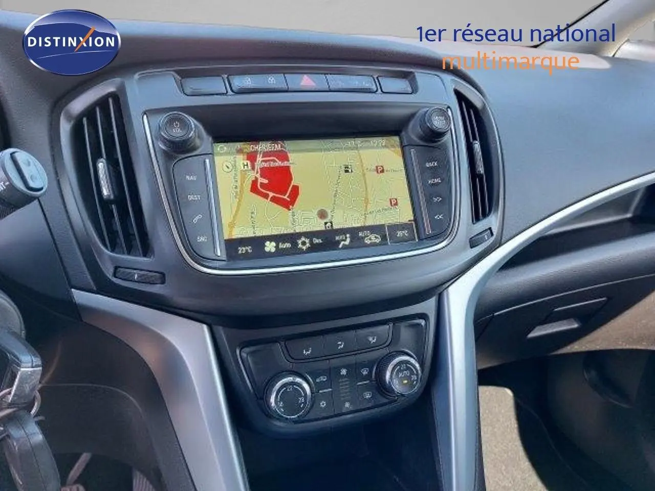 Tableau de bord de l'Opel Zafira 2017 avec écran GPS central et commandes de climatisation en vue rapprochée.