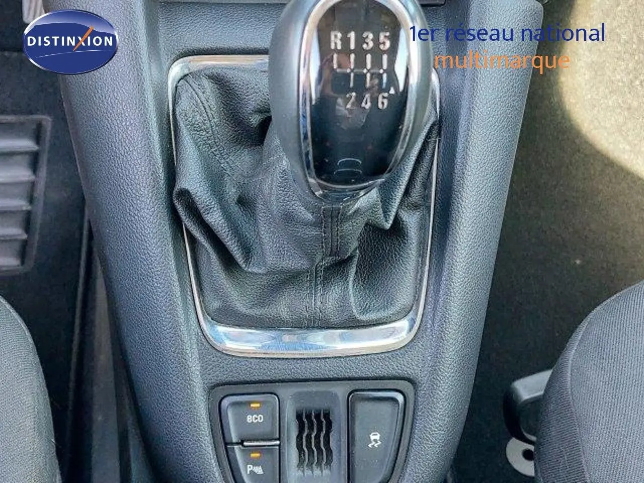 Le levier de vitesses manuel d'une Opel Zafira noire métal de 2017, avec console centrale et boutons de contrôle visibles.