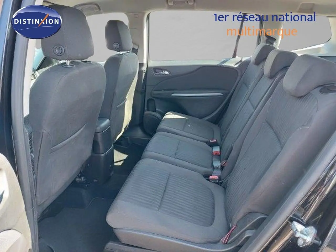 Vue intérieure côté gauche montrant la banquette arrière en tissu gris d'une Opel Zafira noire métallisée de 2017.