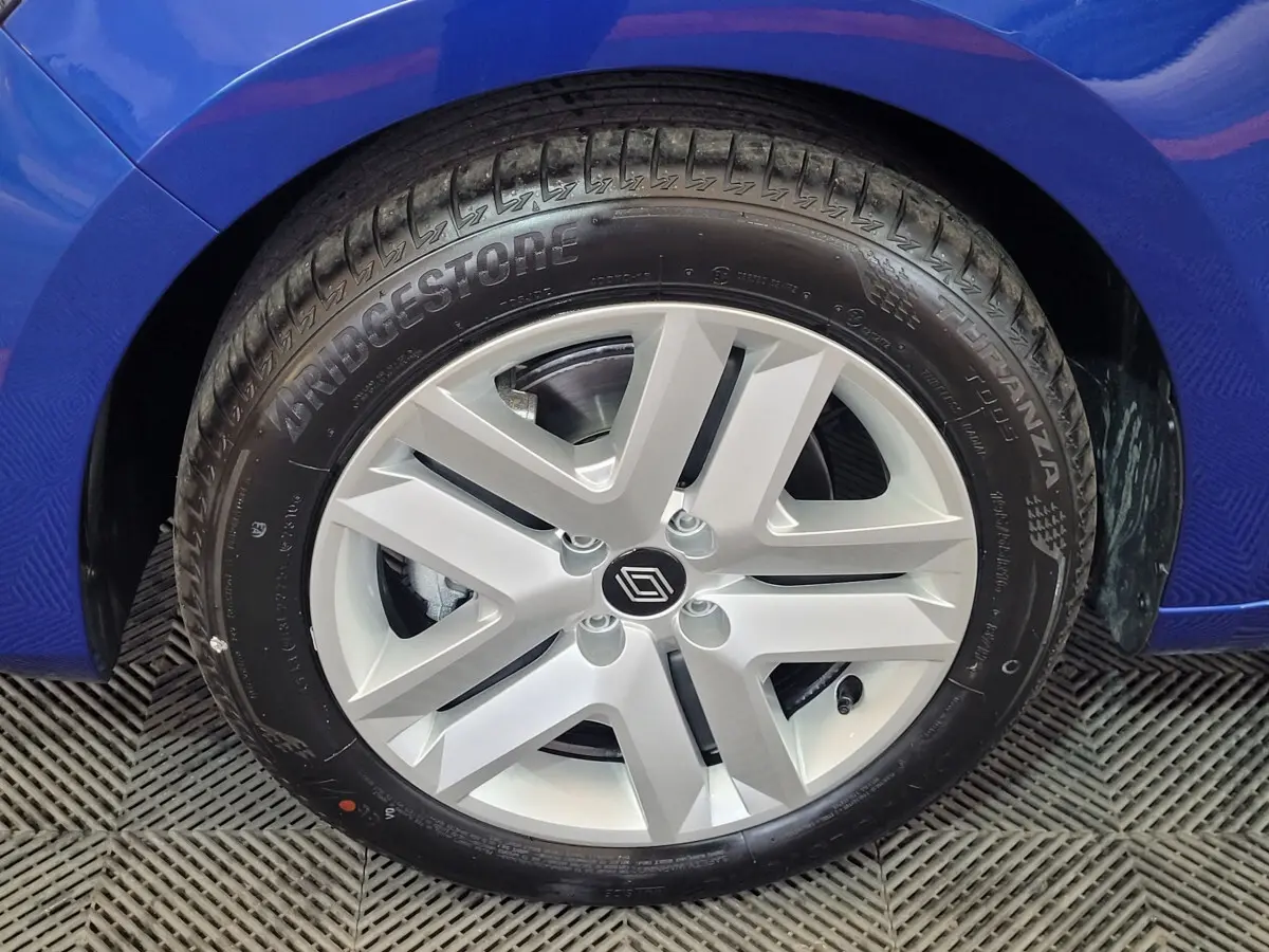 Gros plan sur la roue avant gauche d'une Renault Clio bleu 2025 avec jante argentée et pneu Bridgestone.