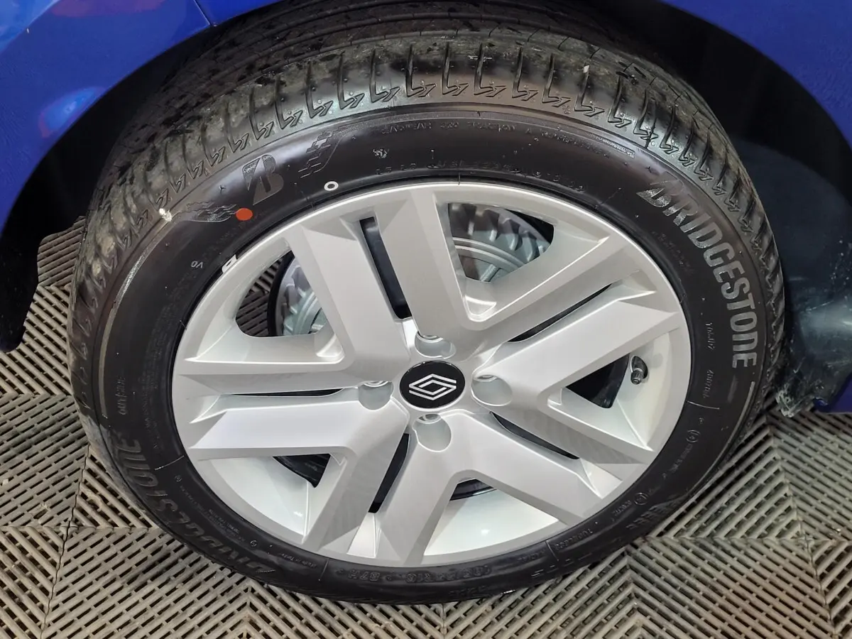 Gros plan sur la roue avant gauche d'une Renault Clio bleu, avec jante argentée au design moderne et pneu Bridgestone.