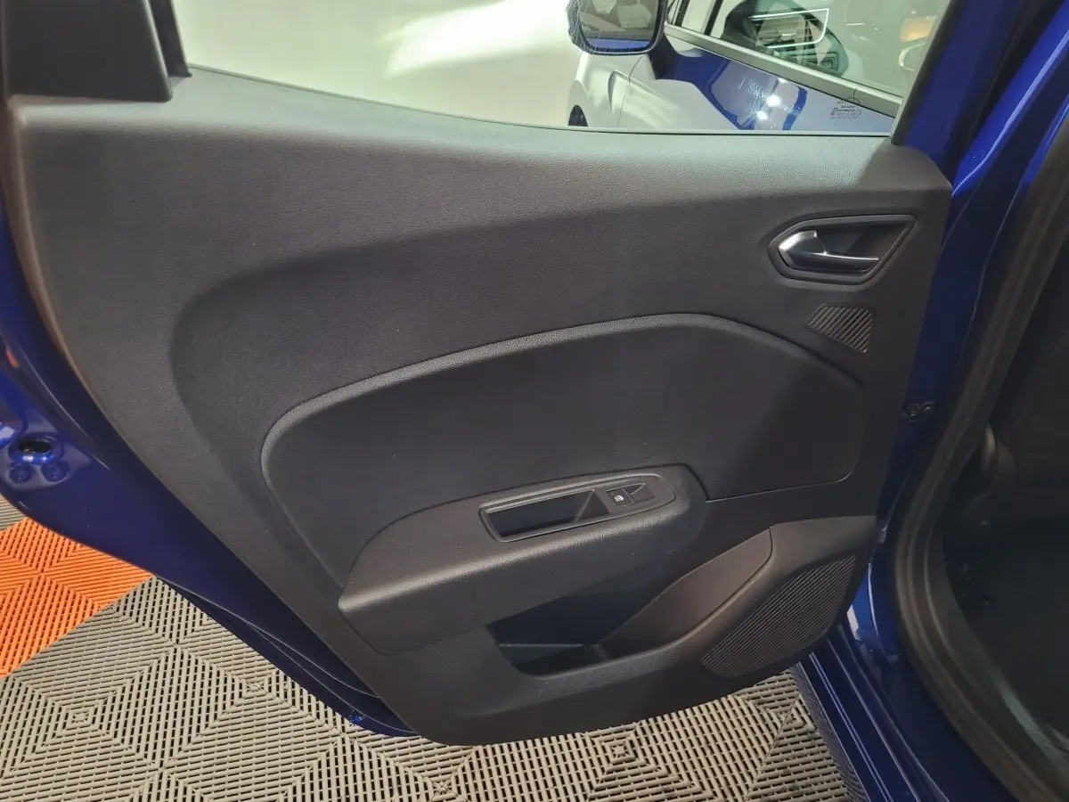 Vue rapprochée de la porte arrière gauche bleu de la Renault Clio 2025 avec commandes de fenêtre et haut-parleur intégré.