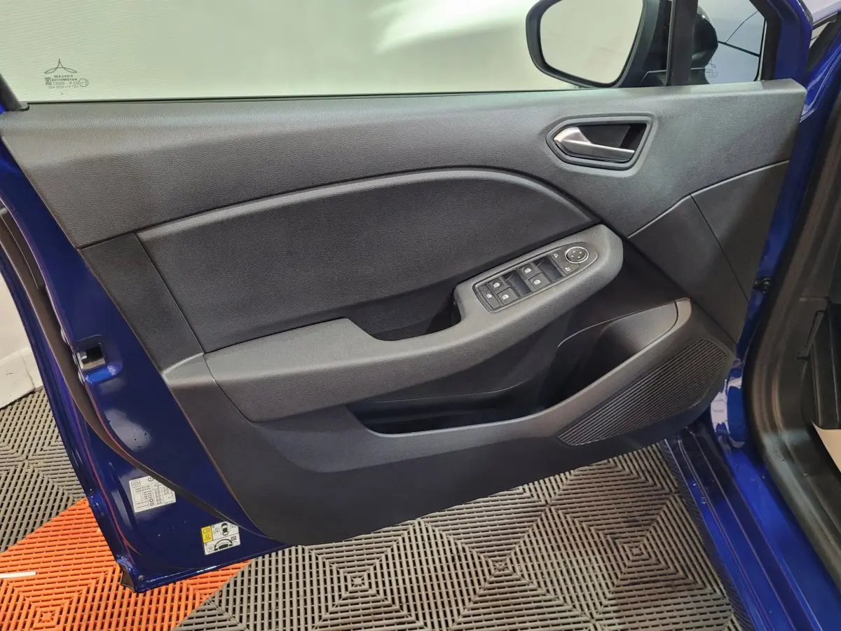 Porte avant gauche ouverte d'une Renault Clio bleu 2025, avec commandes électriques des vitres et haut-parleur intégré.
