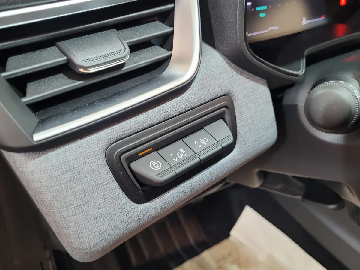 Détail des commandes d'éclairage et verrouillage côté gauche du tableau de bord de la Renault Clio bleu Evolution 2025