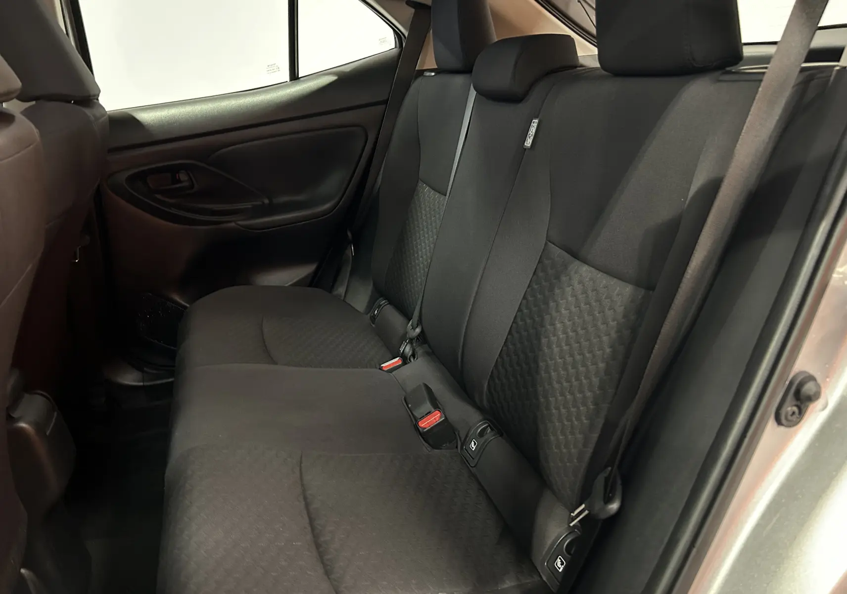 Vue intérieure côté droit des sièges arrière en tissu noir de la Toyota Yaris Cross 116h Active gris minéral 2025.