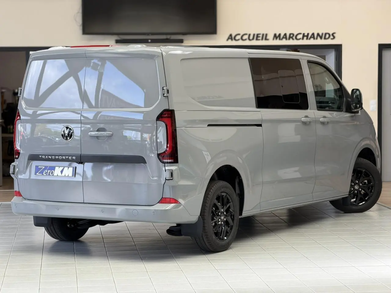 Vue 3/4 arrière droite du Volkswagen Transporter T7 ProCab gris Stone avec jantes noires et feux arrière LED.