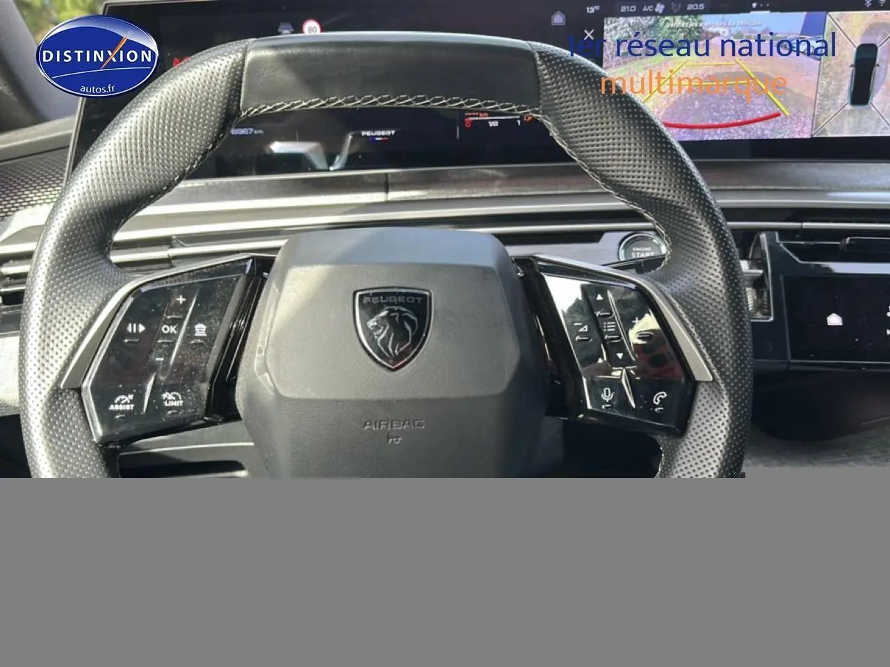 Vue rapprochée du volant cuir noir perforé du Peugeot 3008 gris Artense avec affichage numérique et commandes intégrées.