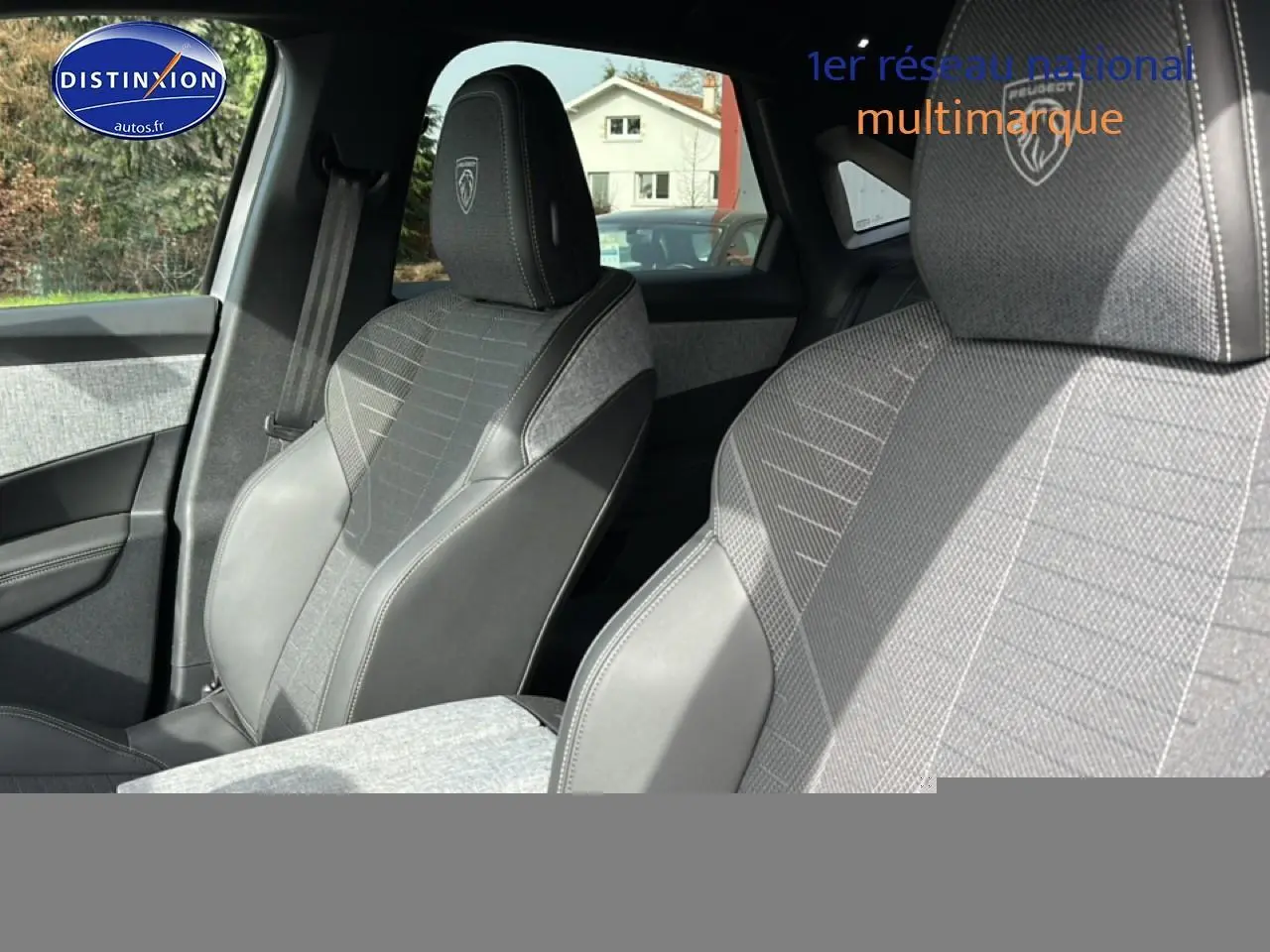 Vue rapprochée des sièges avant gris artense du Peugeot 3008 1.2 hybrid 145 GT avec logo Peugeot brodé sur les appuis-tête.