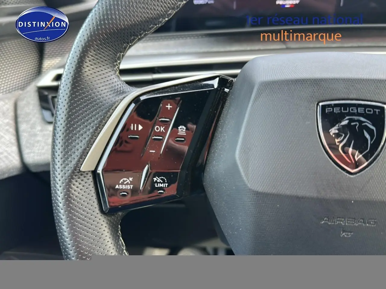 Gros plan sur le volant cuir perforé gris artense du Peugeot 3008 1.2 hybrid 145 GT avec commandes multifonctions.