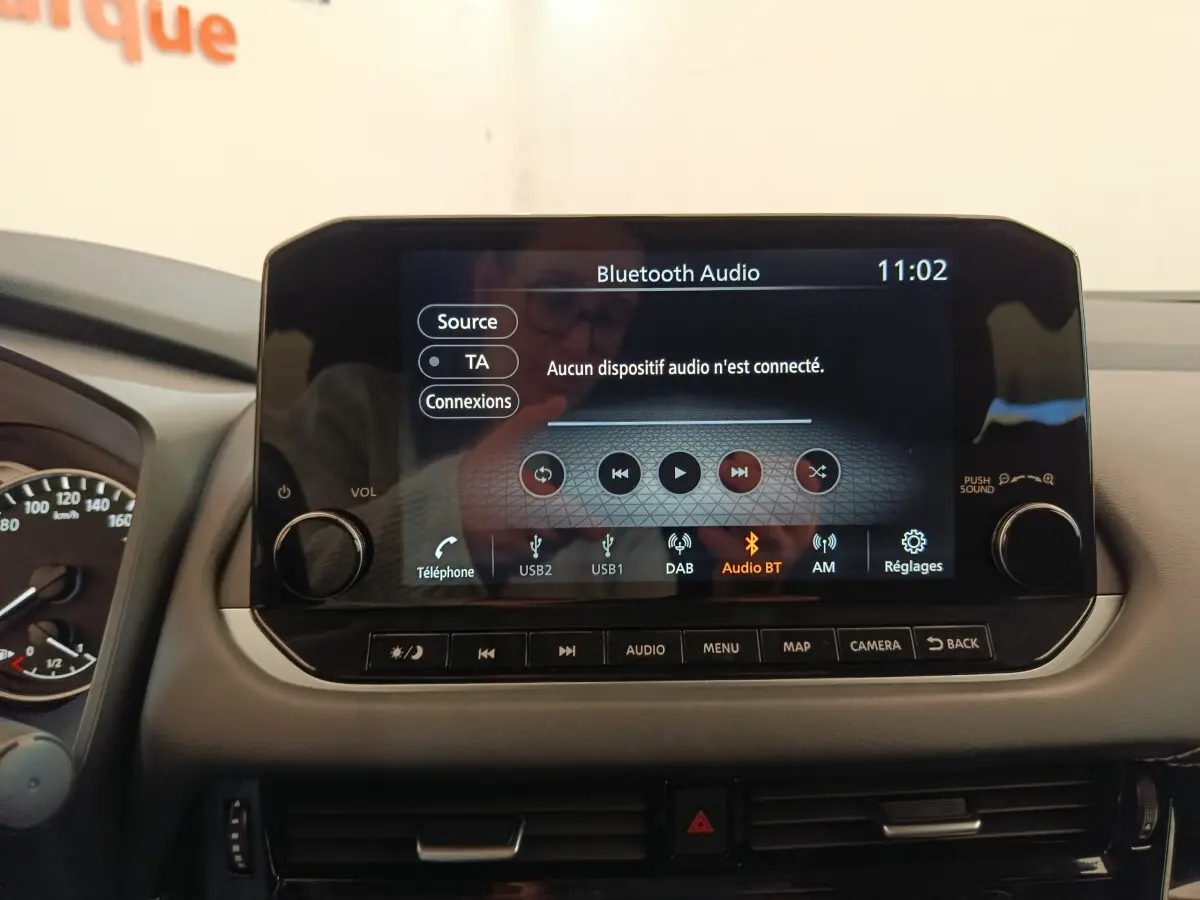 Écran tactile central du tableau de bord du Nissan Qashqai gris foncé, affichant le menu audio Bluetooth.