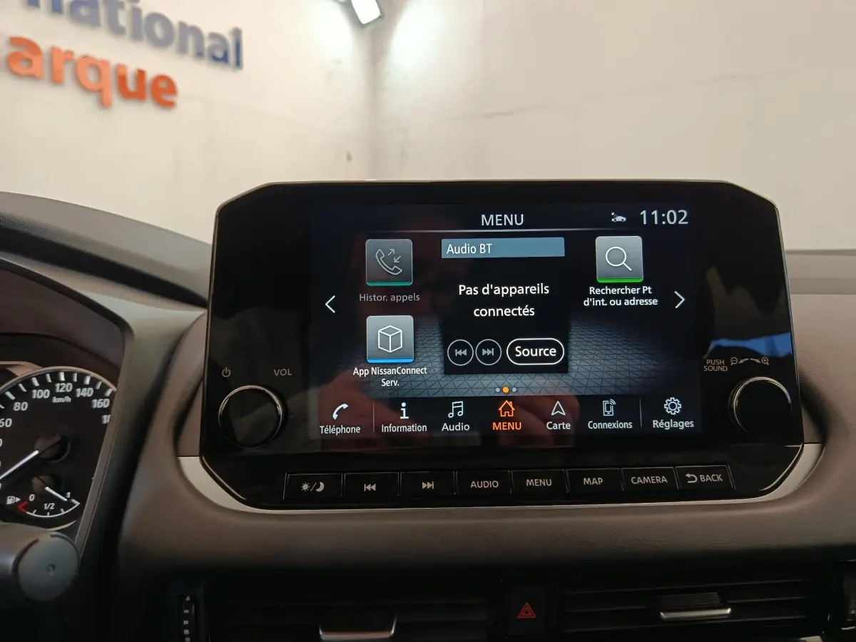 Écran tactile central du Nissan Qashqai 1.3 MHEV 158ch, affichage menu multimédia avec commandes autour.